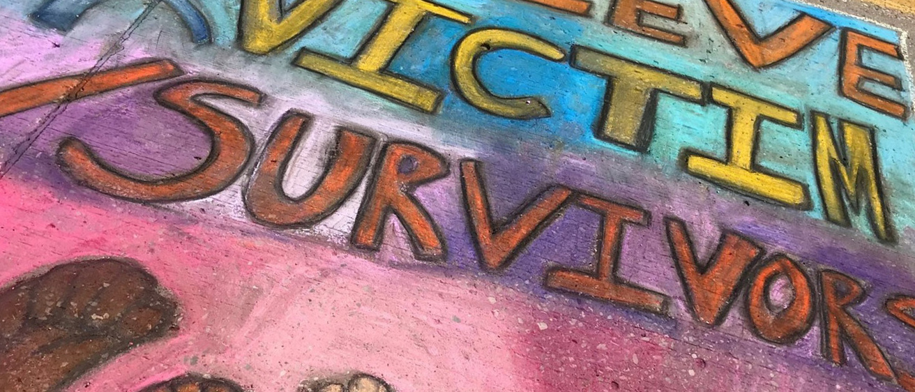 Colorful sidewalk art containing the text "Believe Victim & Survivors"